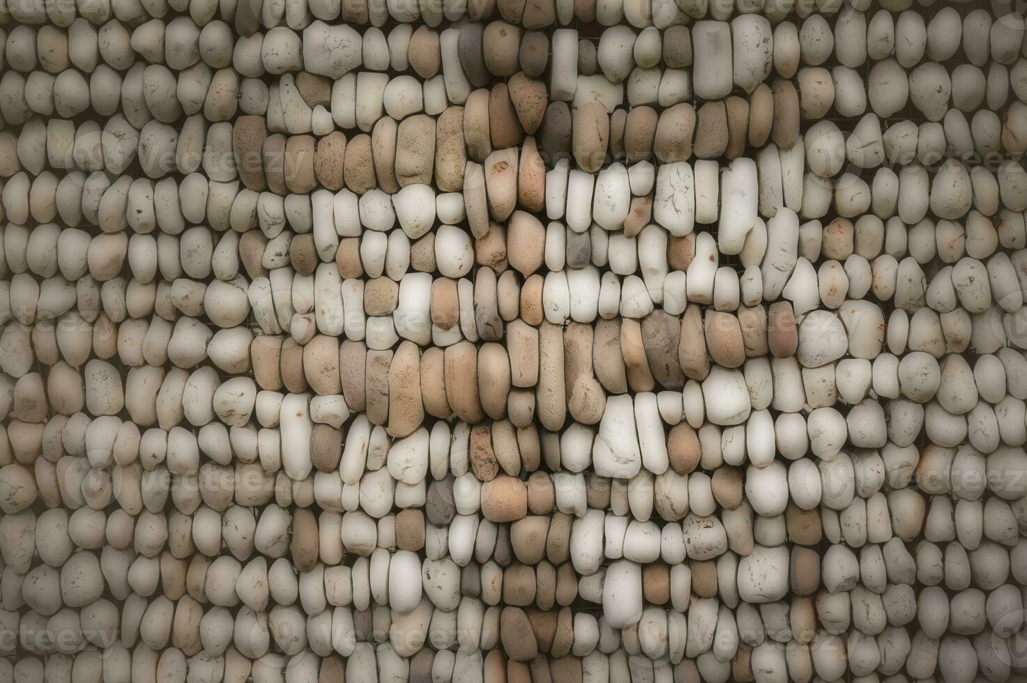 gray brown rock wall background, rock pattern on wall, rocks arranged in a panel on wall photo