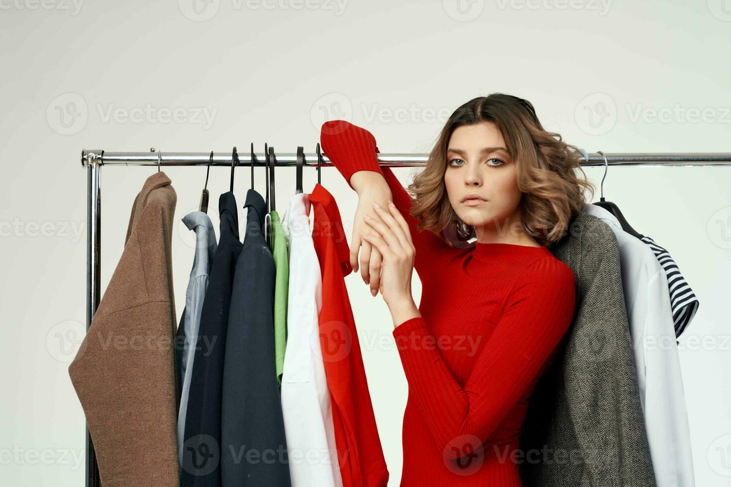 cheerful woman next to clothes fashion fun retail light background photo