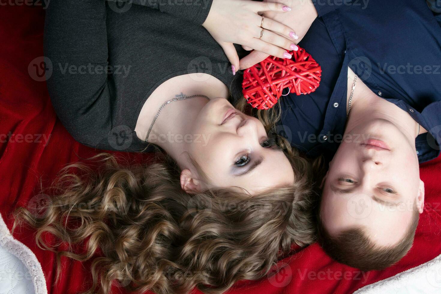 Loving couple from top to bottom. Man and woman with a red heart. Beautiful young husband and wife.Close-up man and woman together.Valentine's day. photo
