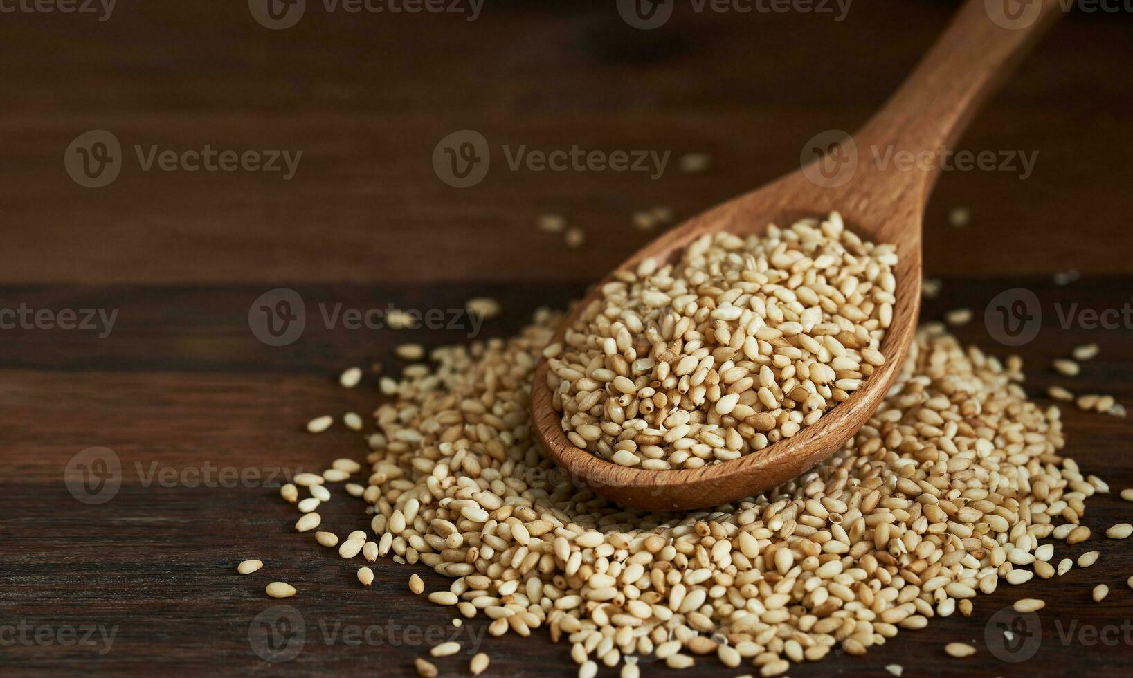sesame seed in wood spoon on wooden table background. a pile of  Toast sesame seeds. sesame seed. pile of sesame seed in wood plate photo