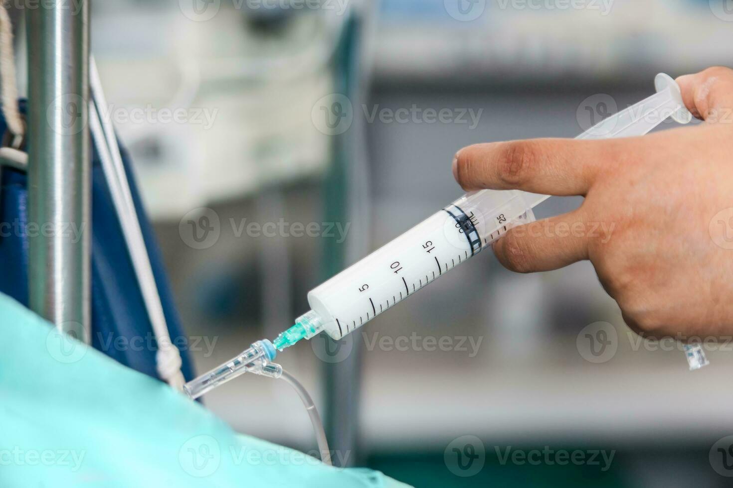 Nurse injecting a drug through an infusion system photo
