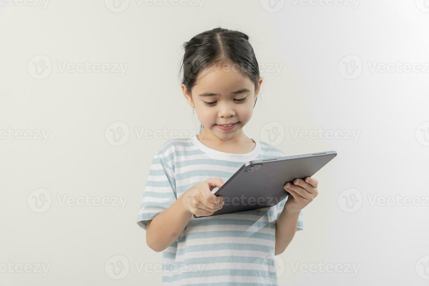 sonriente pequeño niña cosiendo y participación un tableta foto