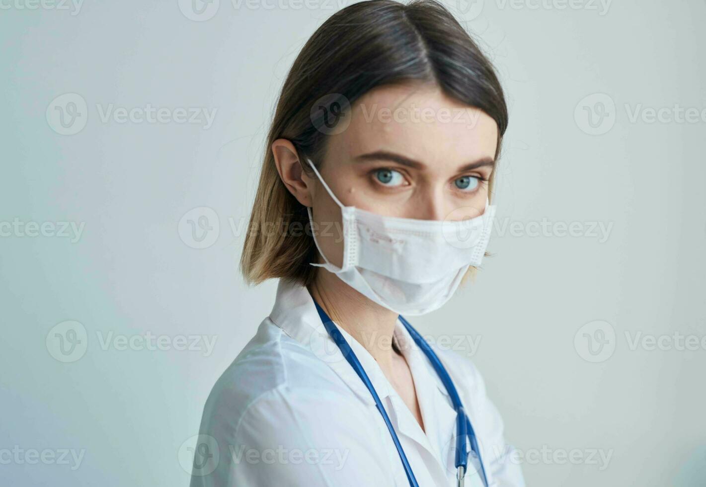 Woman doctor in a medical mask with a stethoscope around her neck photo