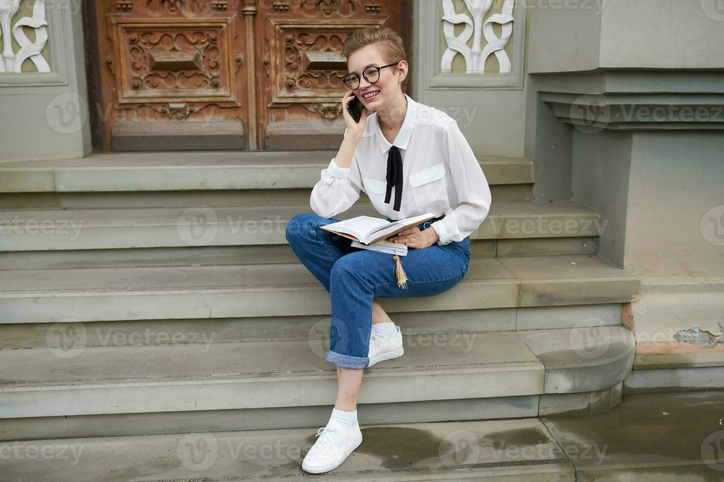 pretty woman with glasses walking around the city with a book education photo