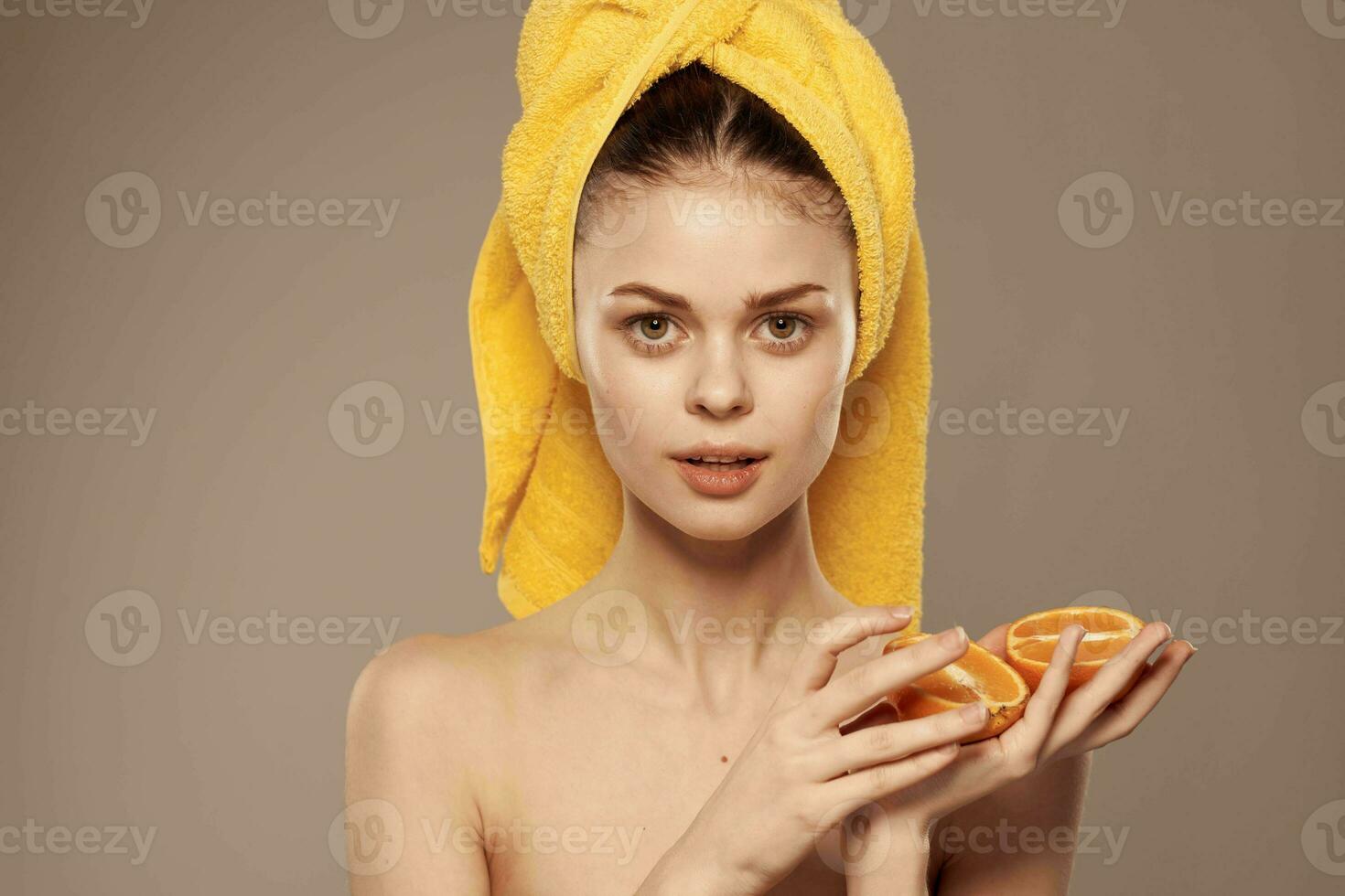 Woman with bared shoulders oranges in hands clean skin health beige