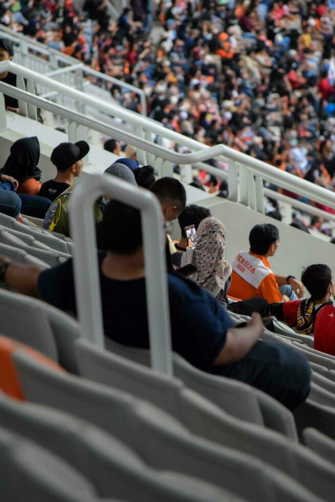 Crowds on Group of fans on the stadium Jakarta International Stadium. Jakarta, Indonesia, August 1, 2022 photo