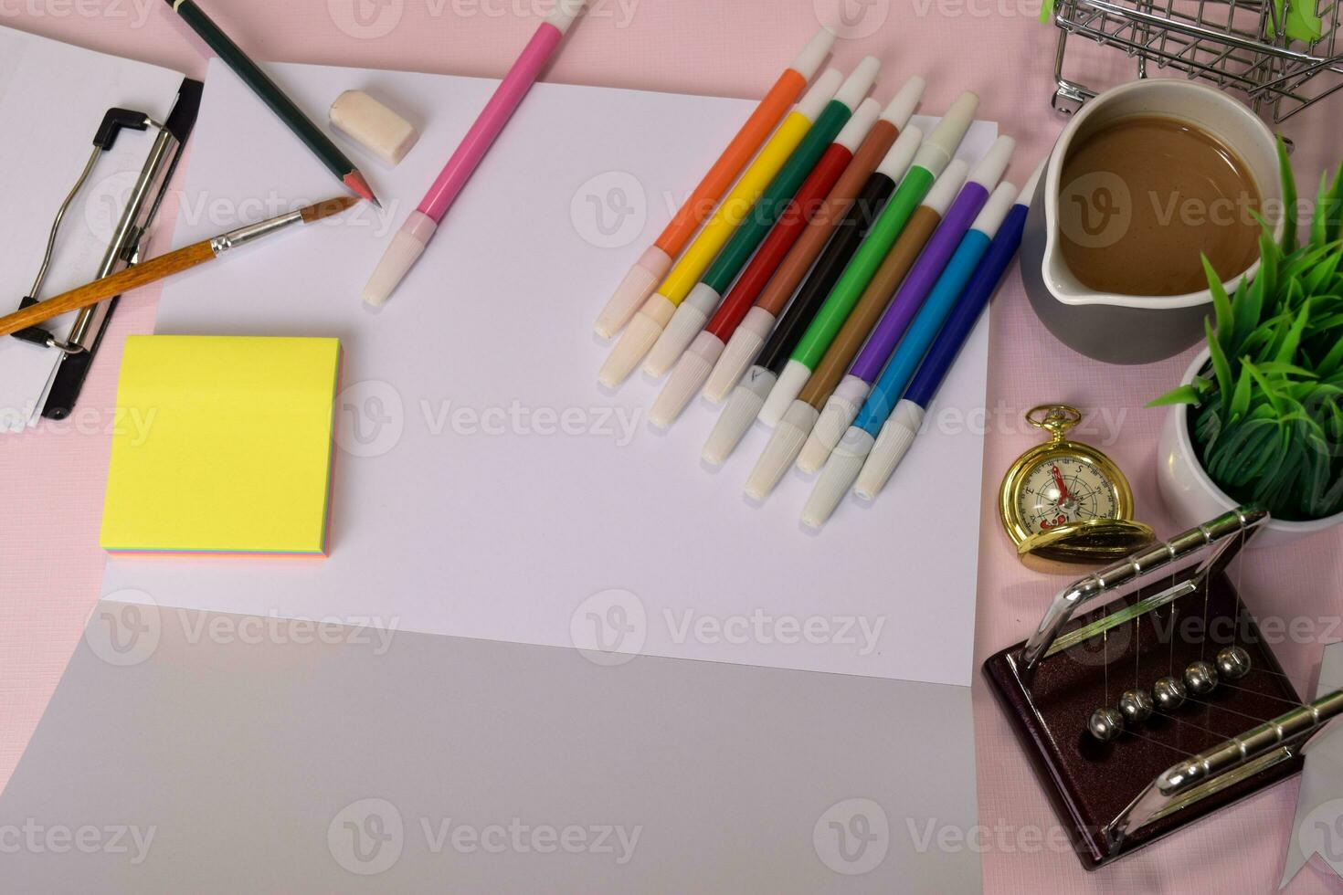 Top view of the open notebook with a marker drawing on a pink table, preparing to do homework. Drawing Working Desk Concept photo