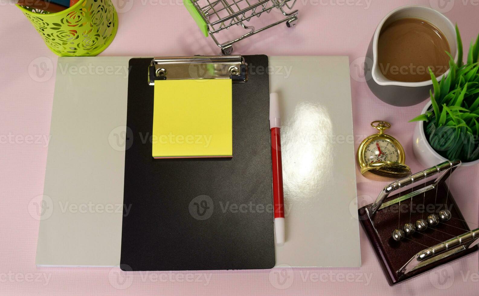 Top view of the notepad and clipboard with a marker drawing on a pink table, preparing to do homework. Drawing Working Desk Concept. photo
