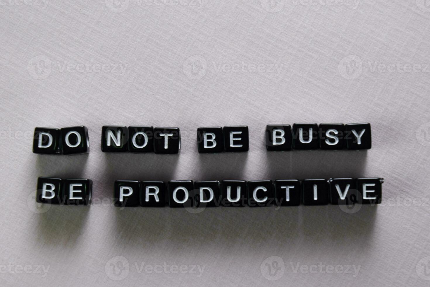 Don't be busy, be productive on wooden blocks. Motivation and inspiration concept photo