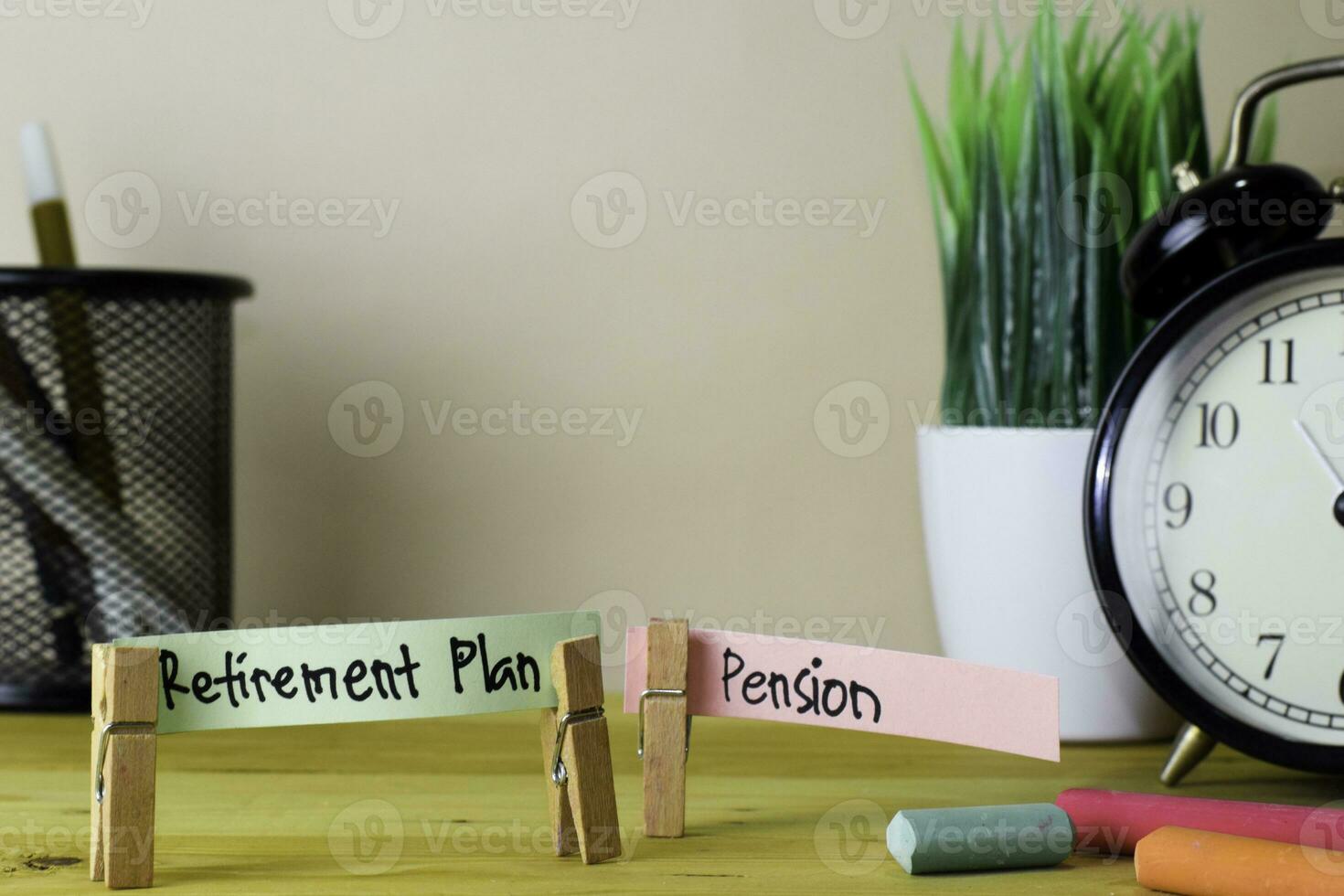 Retirement Plan and Pension. Handwriting on sticky notes in clothes pegs on wooden office desk photo