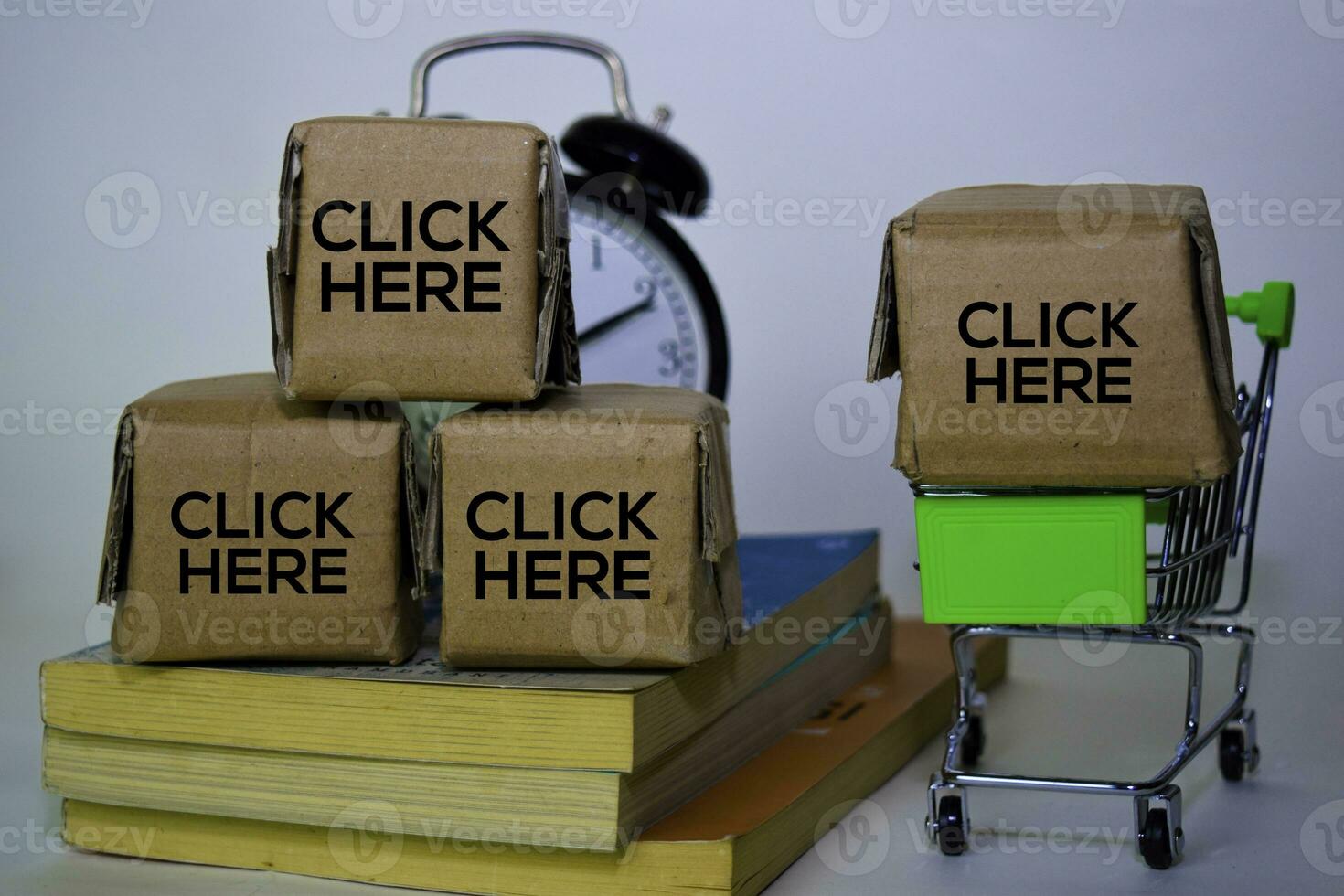 Click Here Text in small boxes and shopping cart. Concepts about online shopping. Isolated on white background photo