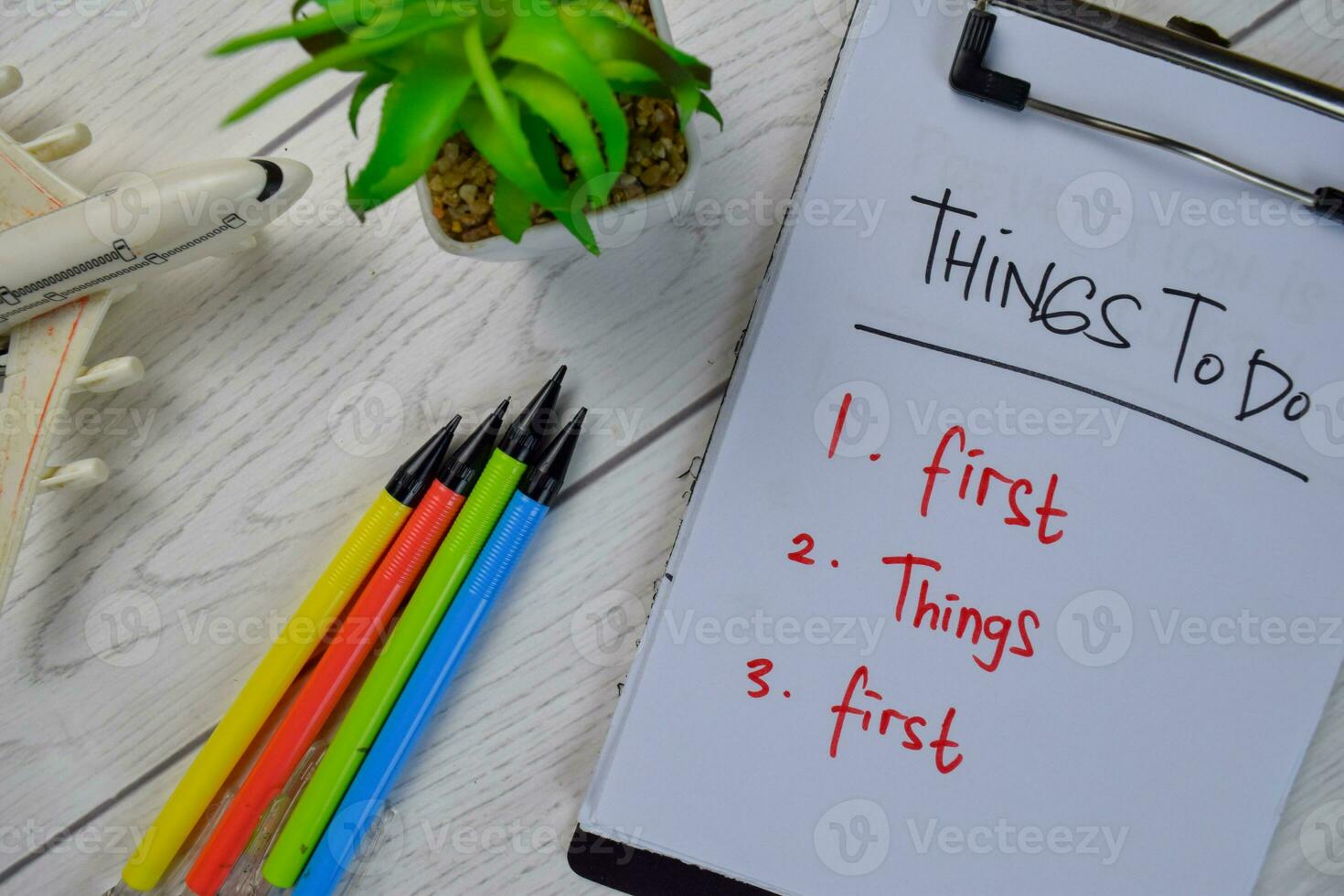 Things To Do - First Things First write on a paperwork and supported by additional services isolated on Wooden Table. photo