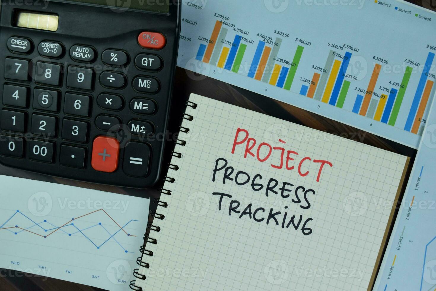 Project Progress Tracking write on a book isolated on Wooden Table. photo