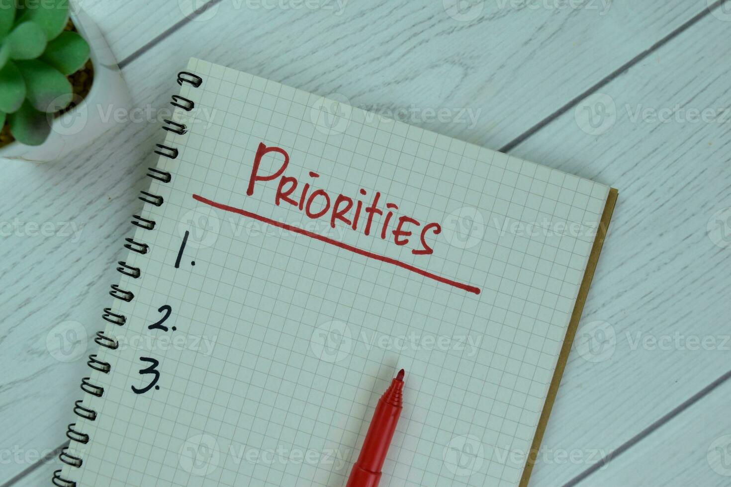 Set Priorities write on a book isolated on Wooden Table. photo