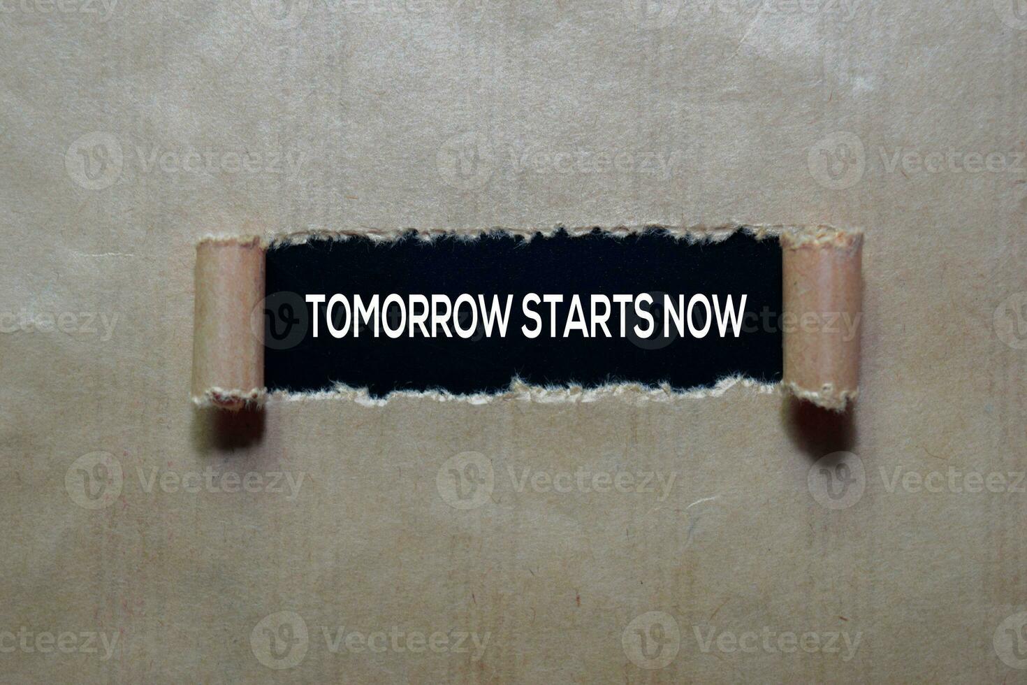 Tomorrow Starts Now Text written in torn paper photo