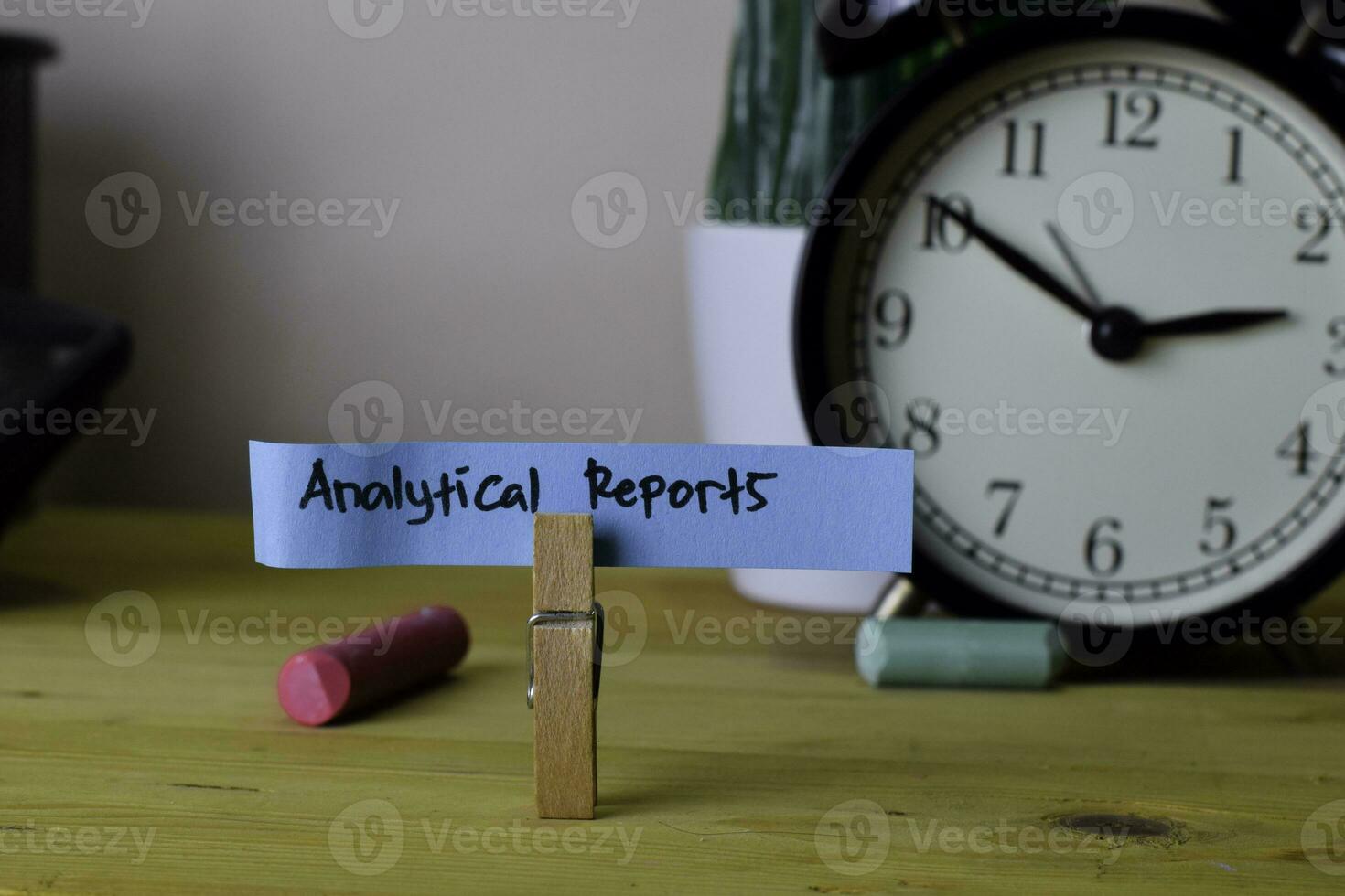analytical Reports. Handwriting on sticky notes in clothes pegs on wooden office desk photo
