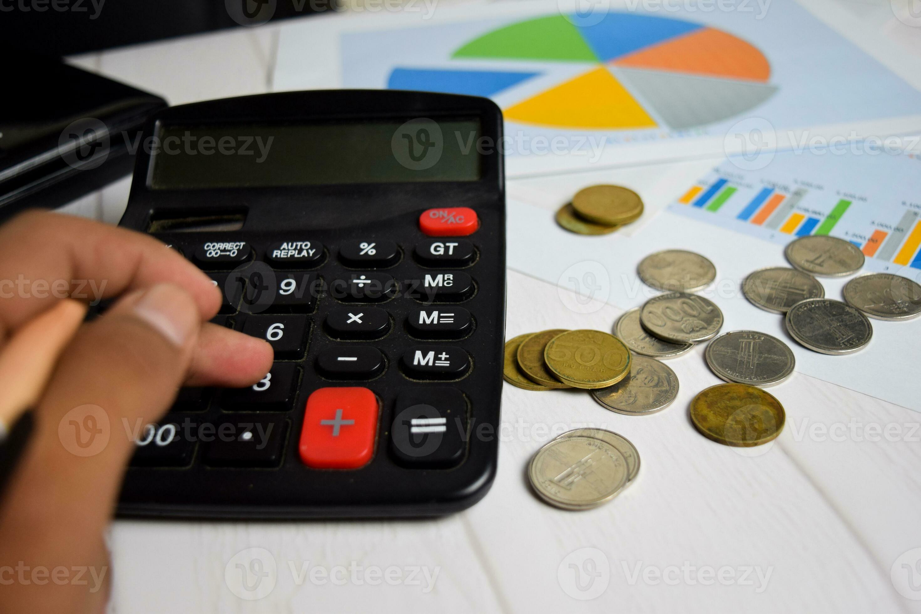A mand calculating the stack of coin on office desk. salary or tax