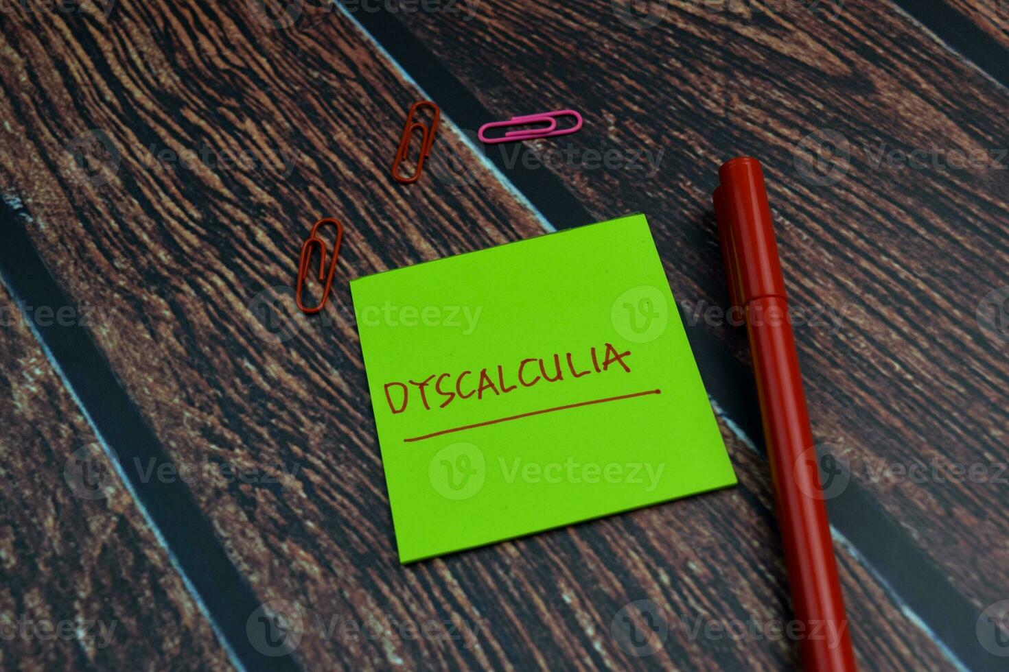 Dyscalculia write on a sticky note Isolated on wooden table background photo