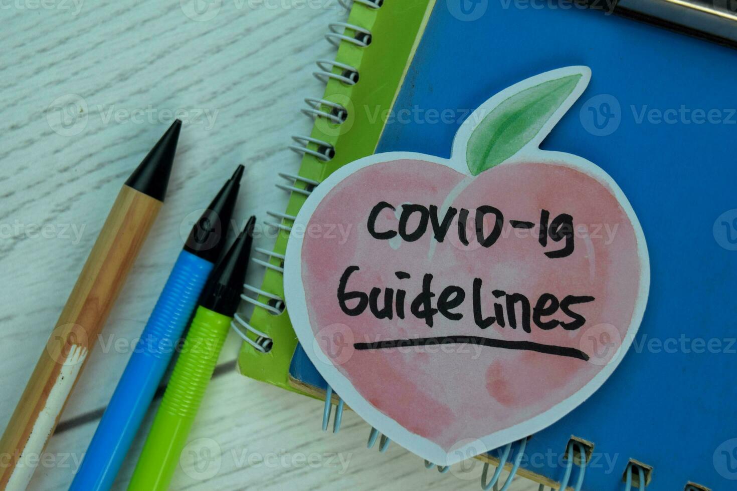 Covid-19 Guidelines write on sticky notes isolated on office desk. photo