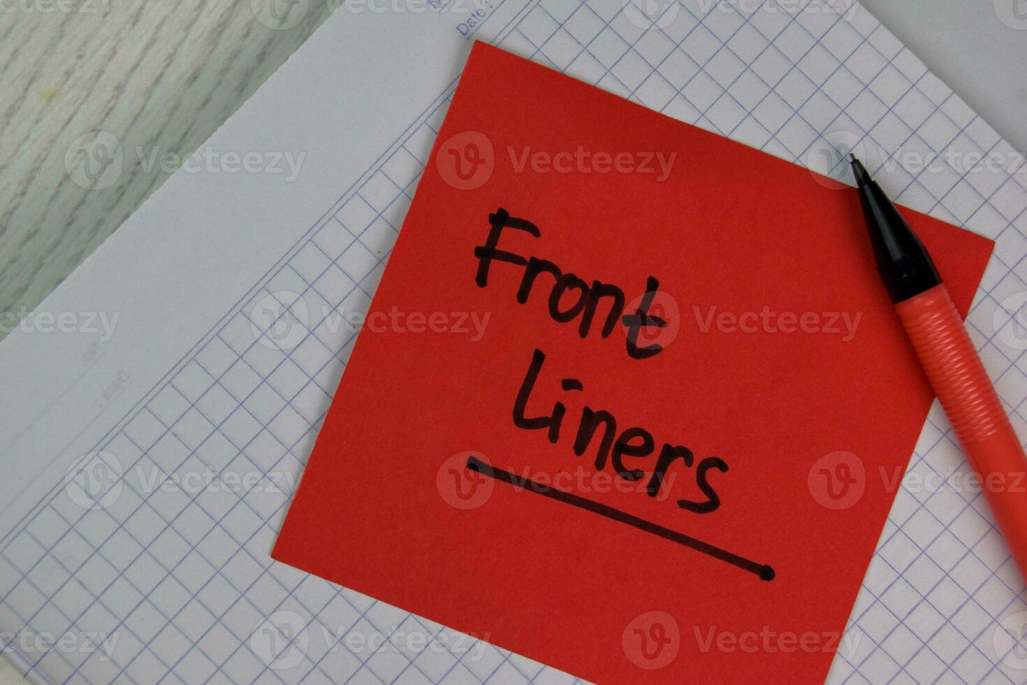 Front Liners write on sticky notes isolated on Wooden Table. photo