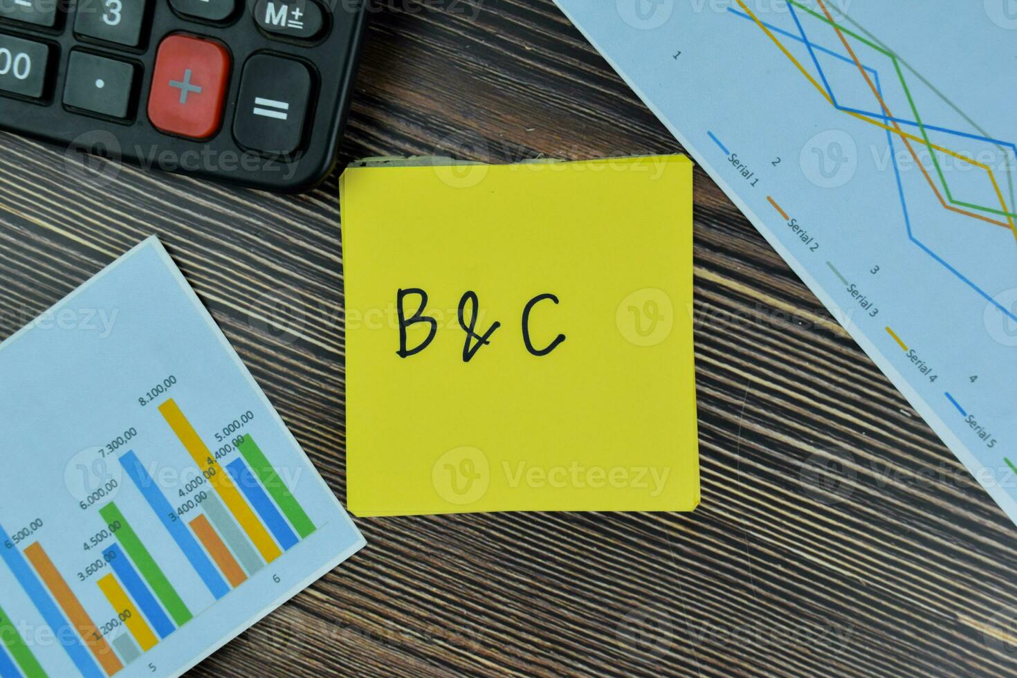 B and C write on sticky notes isolated on Wooden Table. photo
