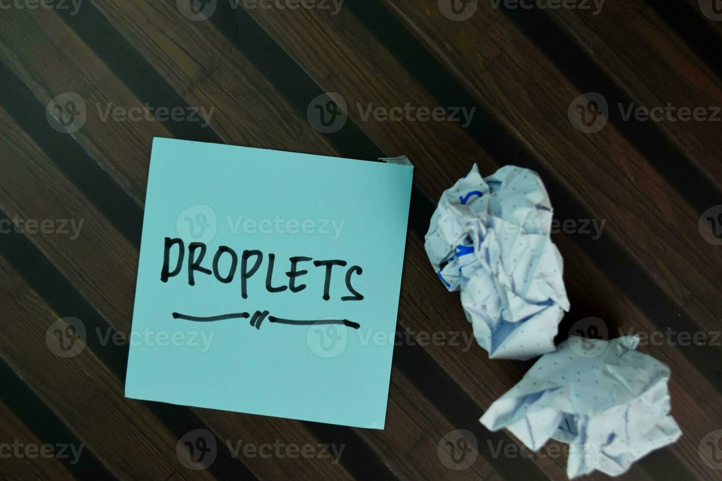 Droplets write on sticky notes isolated on Wooden Table. photo