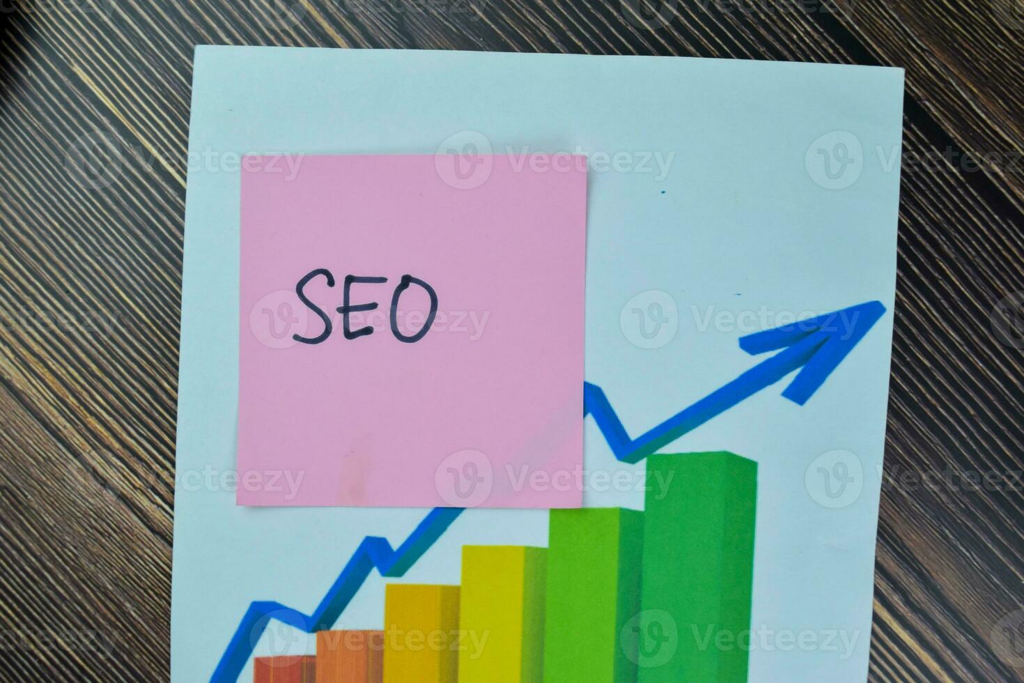 Concept of SEO write on sticky notes isolated on Wooden Table. photo