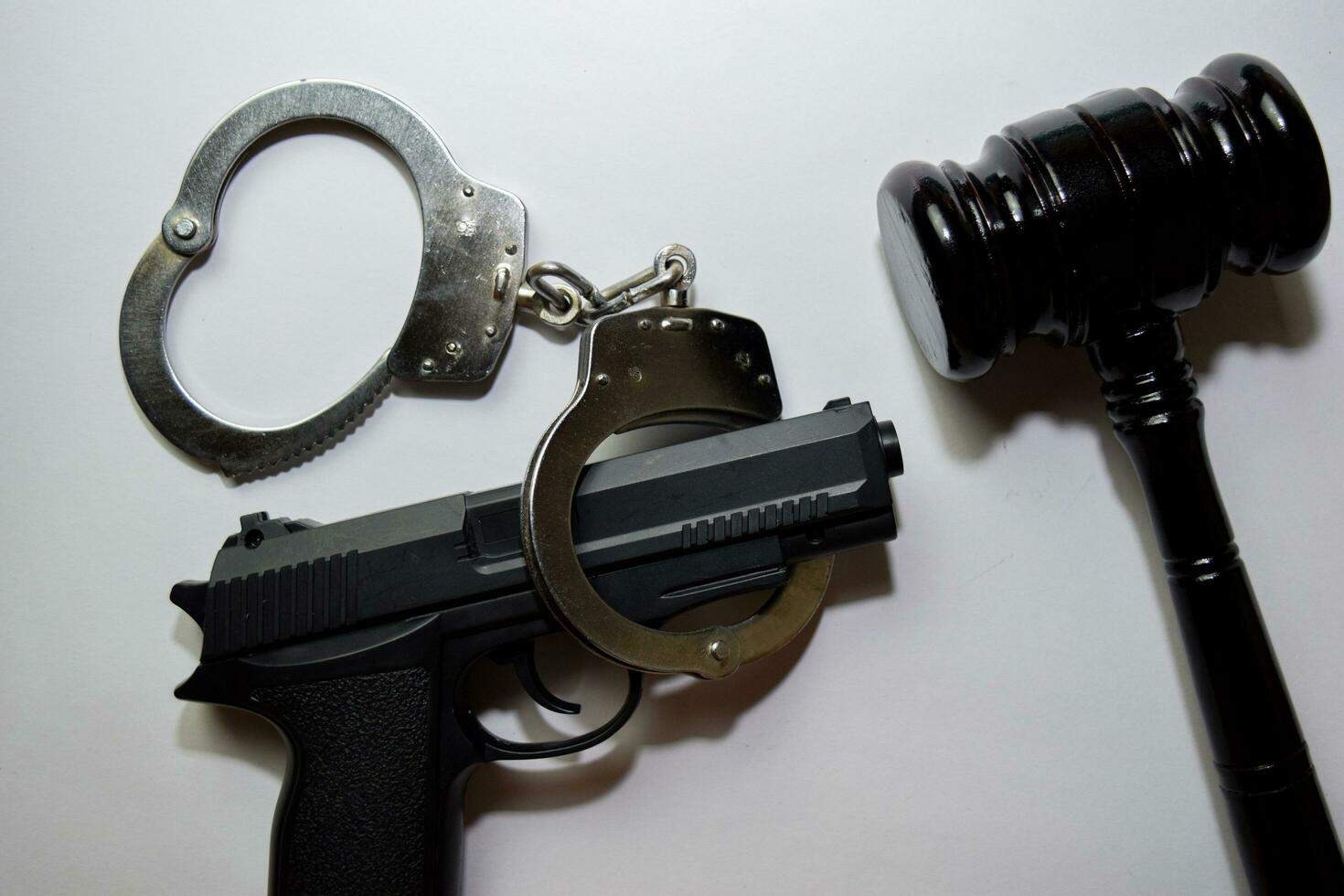 gun, handcuffs and black gavel isolated on white background. Justice and law concept photo
