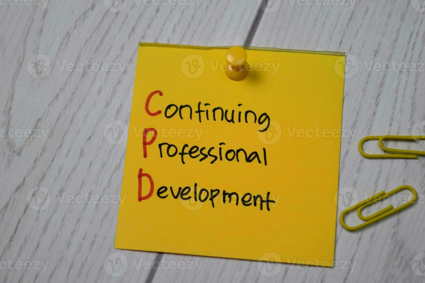 Continuing Professional Development write on sticky note isolated on wooden table. photo