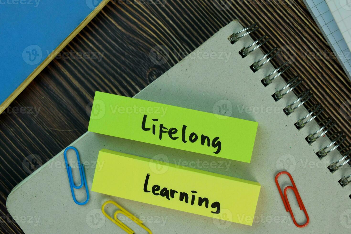 Lifelong learning write on sticky notes isolated on Wooden Table. Education concept photo