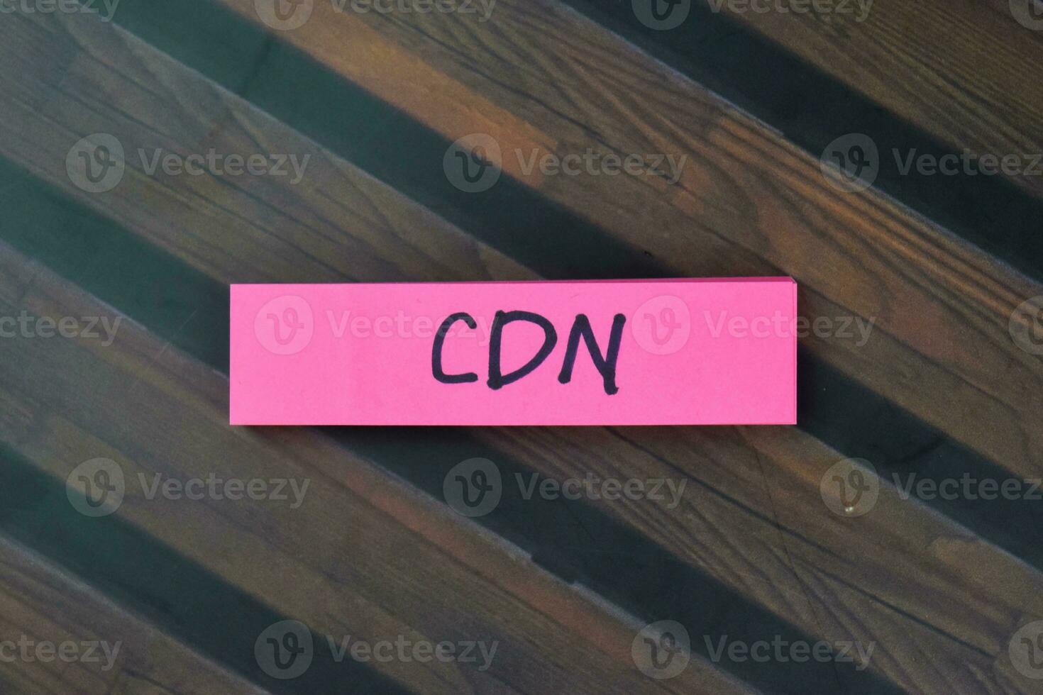 Concept of CDN - Content Delivery Network write on sticky notes isolated on Wooden Table. photo