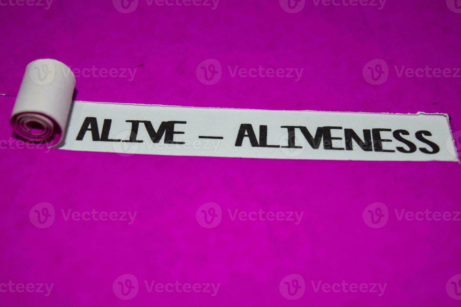 Alive - Aliveness text, Inspiration and positive vibes concept on purple torn paper photo