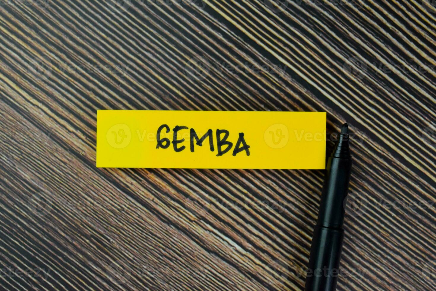 Gemba write on sticky notes isolated on Wooden Table. photo
