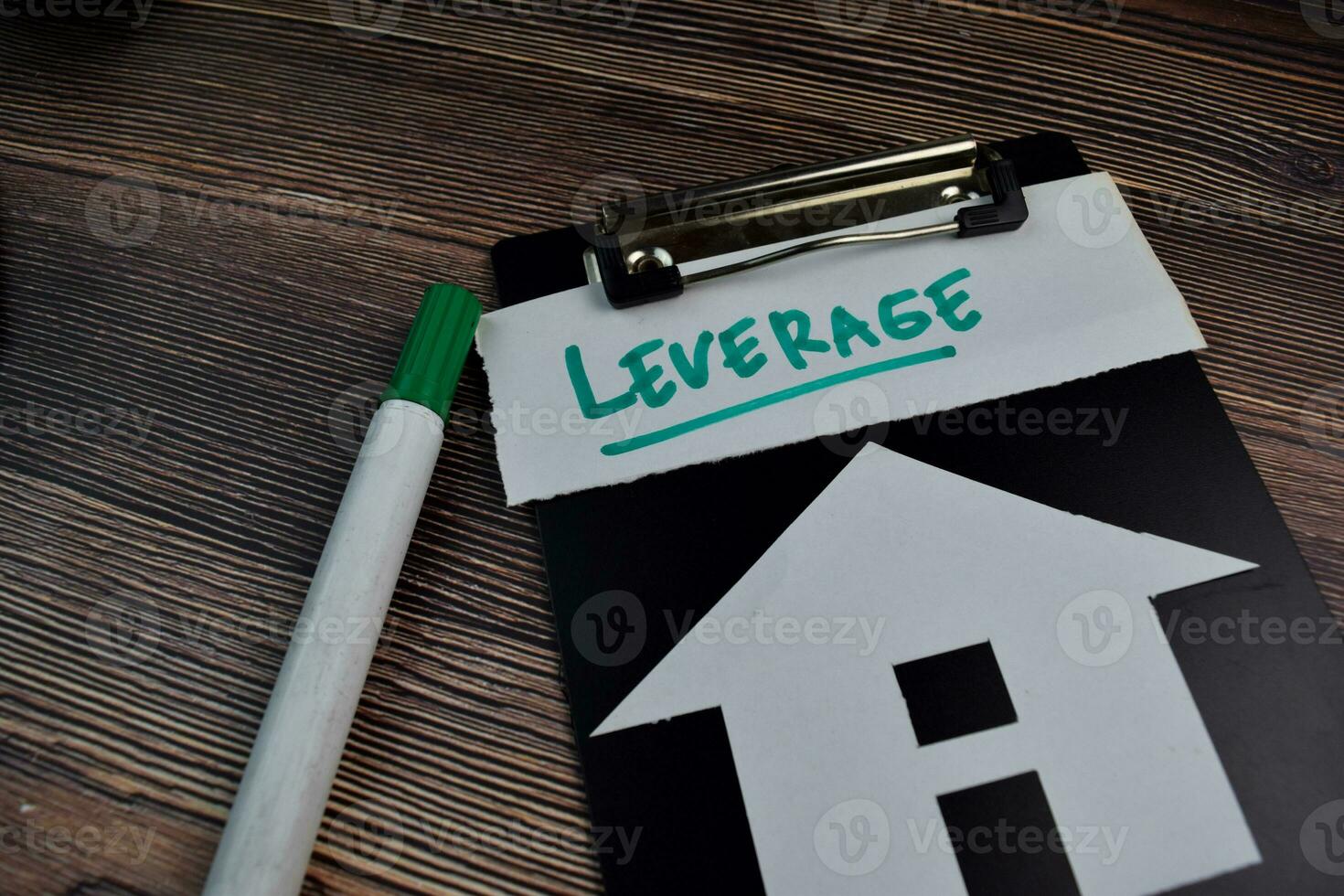 Leverage write on sticky notes and house made from paper isolated on the table. photo