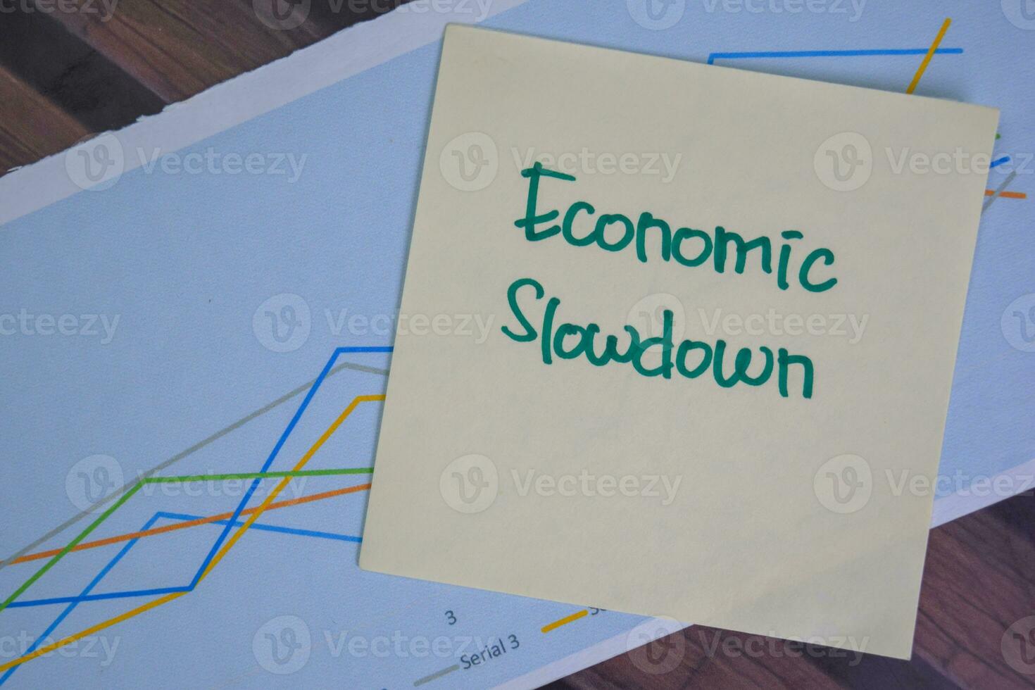Economic Slowdown write on sticky notes isolated on Wooden Table. photo