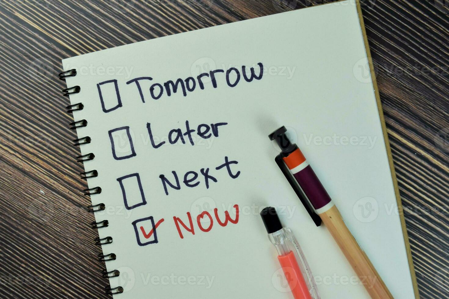 Concept of marking checkbox of now, later, next and tomorrow write on a book isolated on Wooden Table. photo