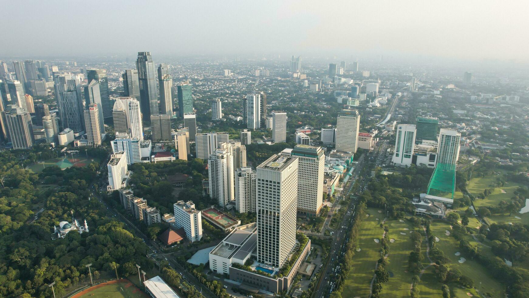 Aerial view of office buildings in Jakarta central business district and noise cloud when sunset. Jakarta, Indonesia, December 21, 2022 photo