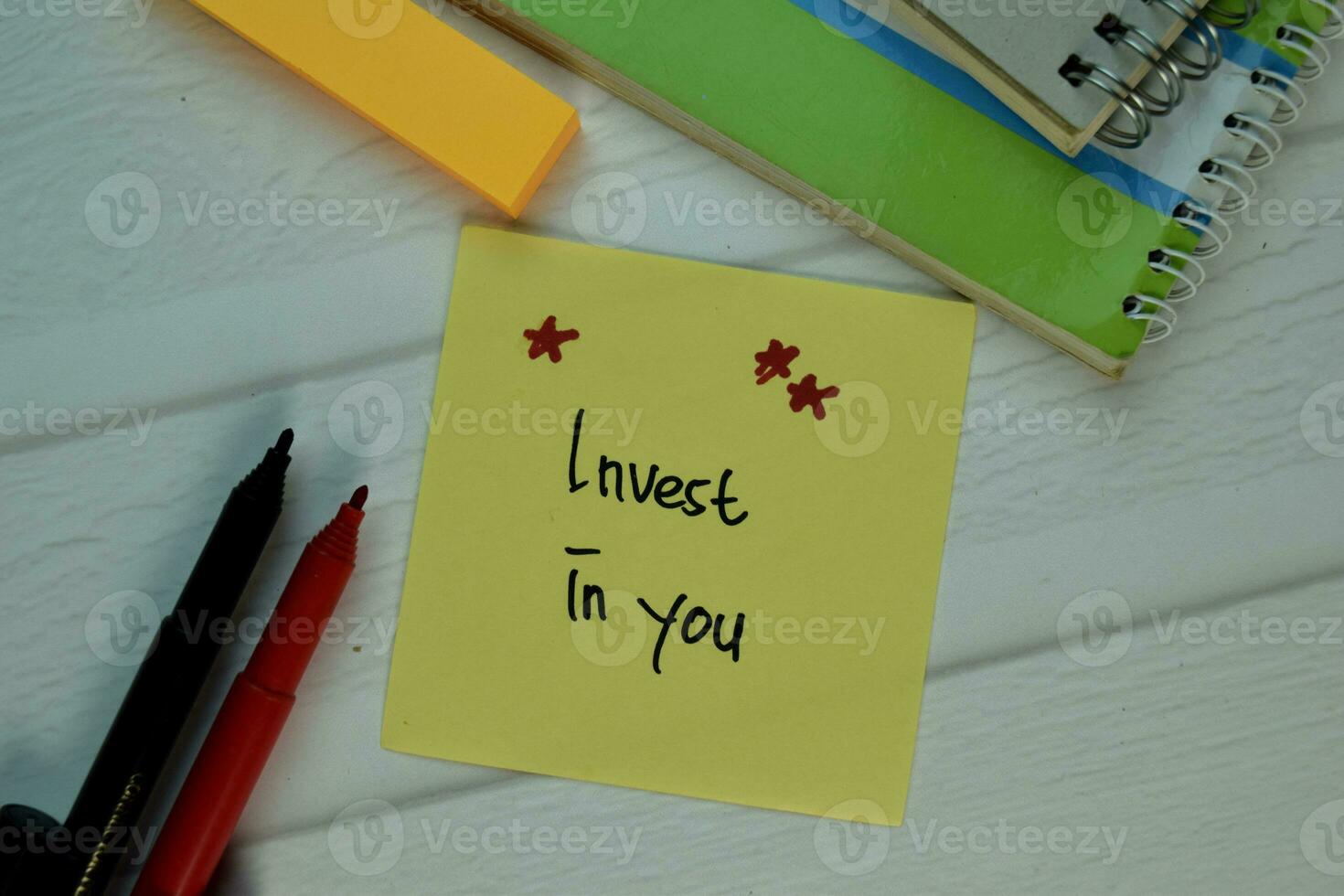 Invest in You write on sticky note isolated on Wooden Table. Selective focus on Invest in You text photo
