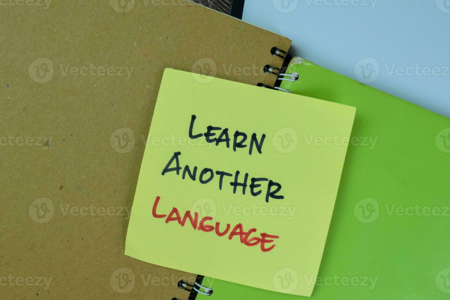 Concept of Learn Another Language write on sticky notes isolated on Wooden Table. photo