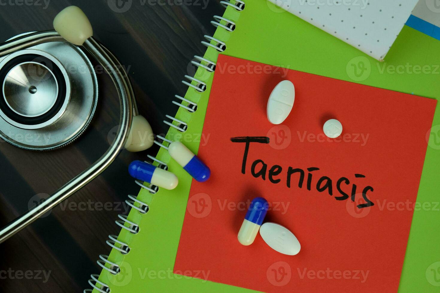 Taeniasis write on sticky notes isolated on Wooden Table. Medical or Healthcare concept photo