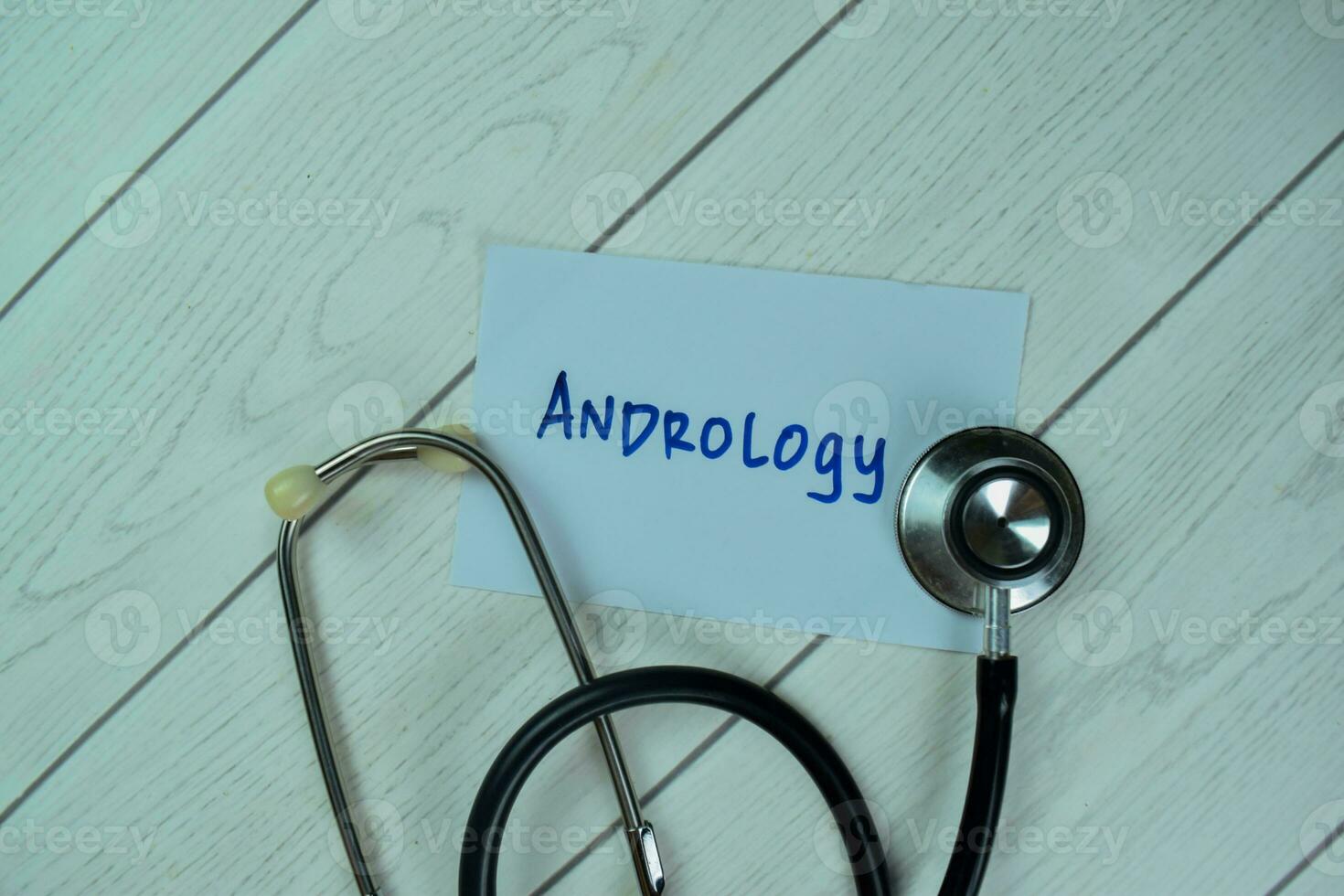 Concept of Andrology write on sticky notes with stethoscope isolated on Wooden Table. photo