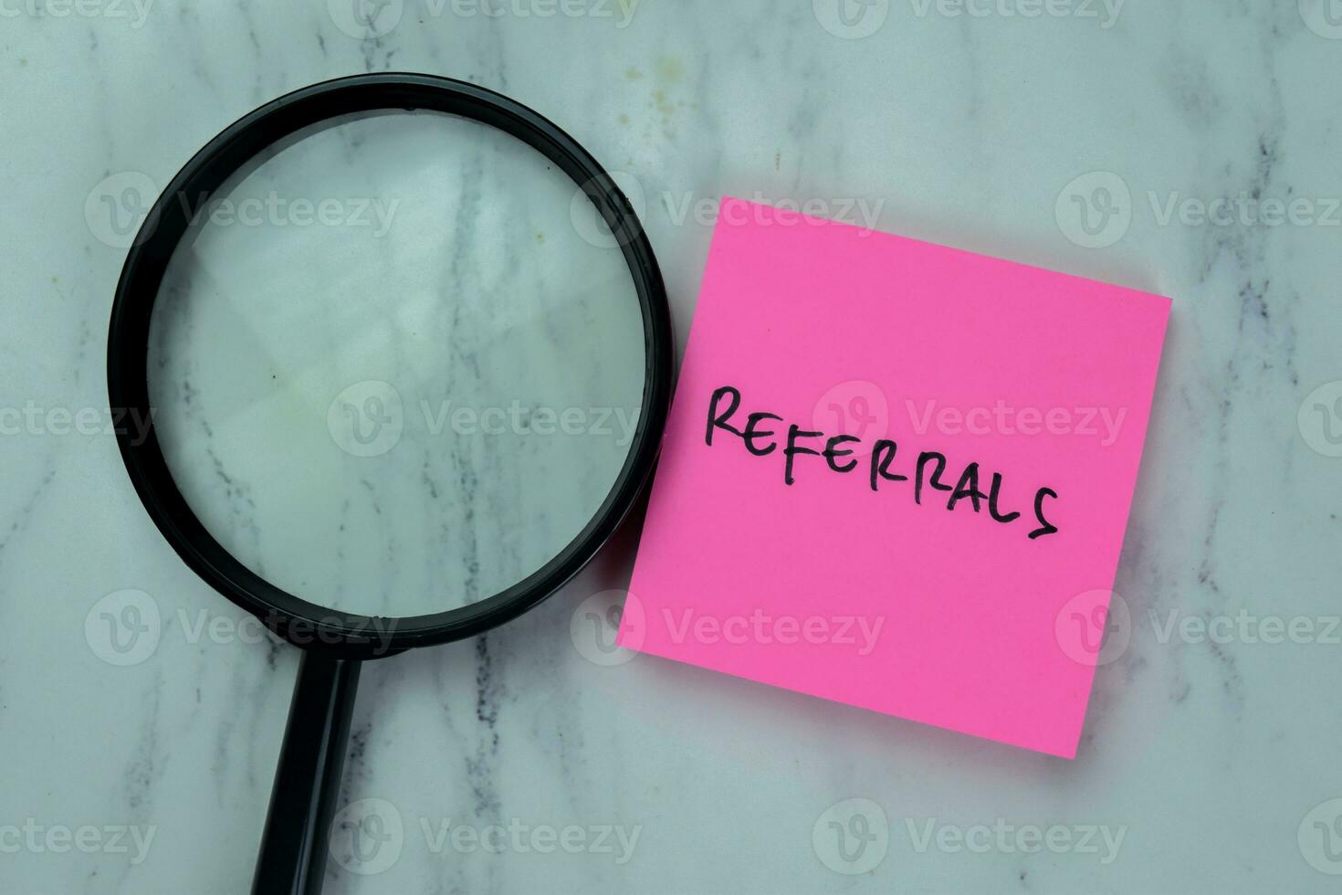 Concept of Referrals write on sticky notes isolated on Wooden Table. photo