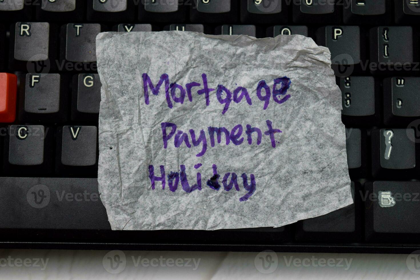 Mortgage Payment Holiday write on crunched paper isolated on wooden table. photo