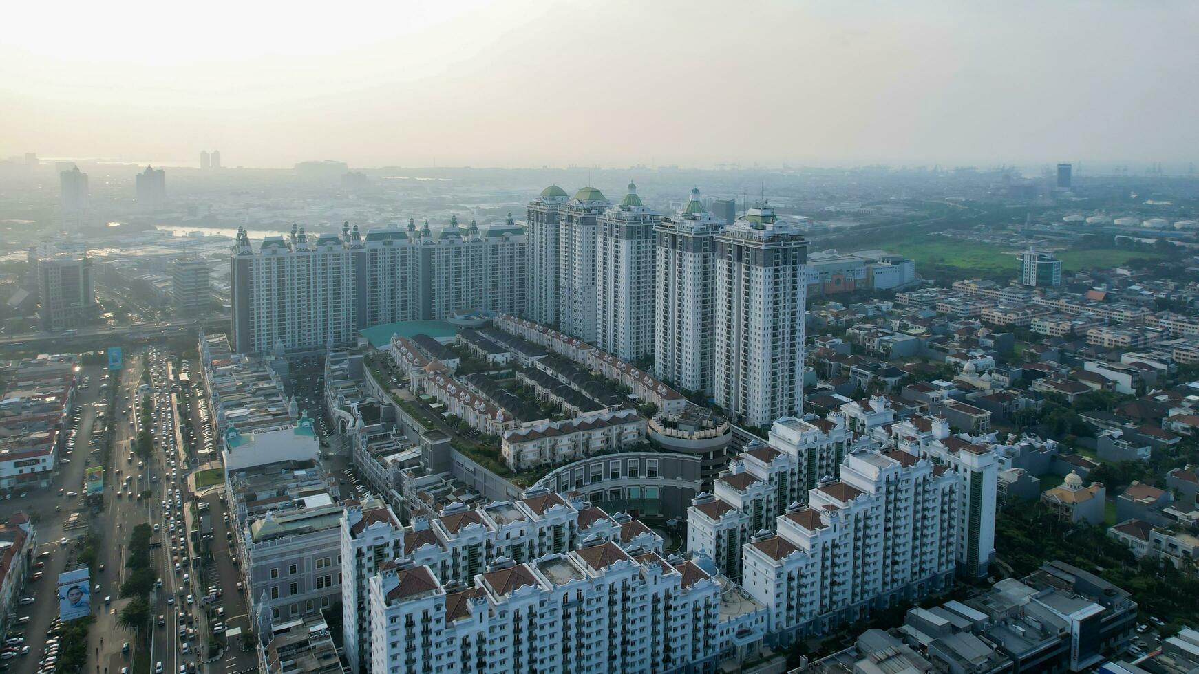 Aerial view of new green urban landscape in the city. Cityscape of a residential area with modern apartment buildings when sunset with noise cloud. Jakarta, Indonesia, Juni 23, 2022 photo