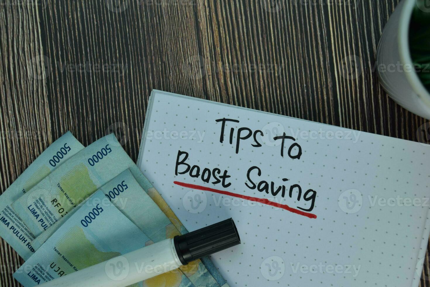 Tips To Boost Saving write on a book isolated on Wooden Table. Financial Concept photo