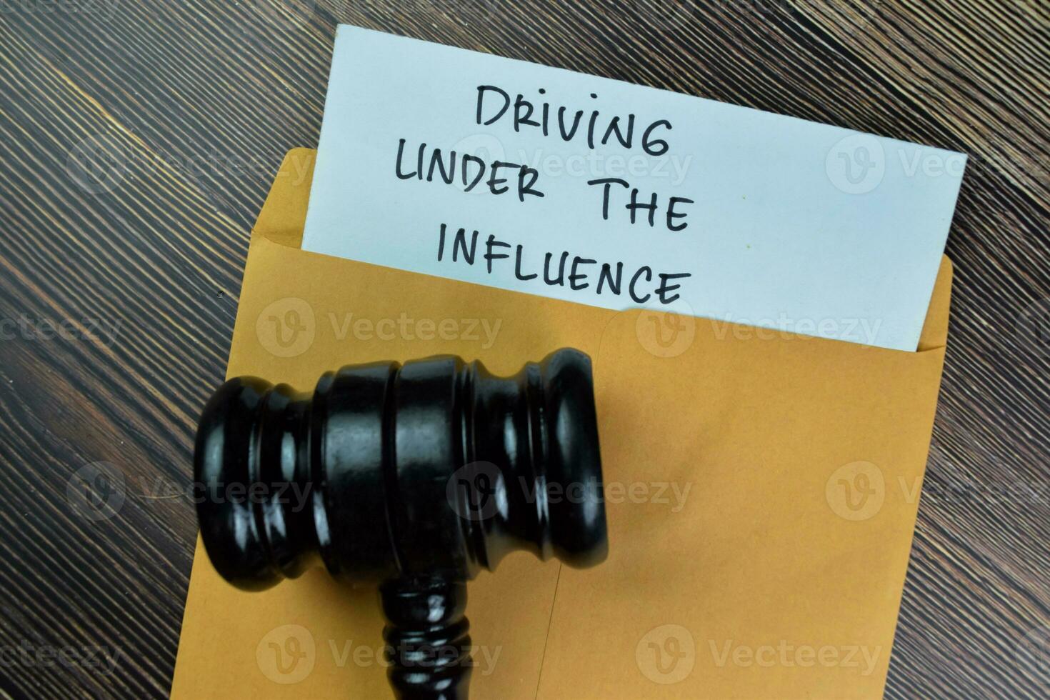 Driving Under The Influence text on document with gavel above brown envelope. photo