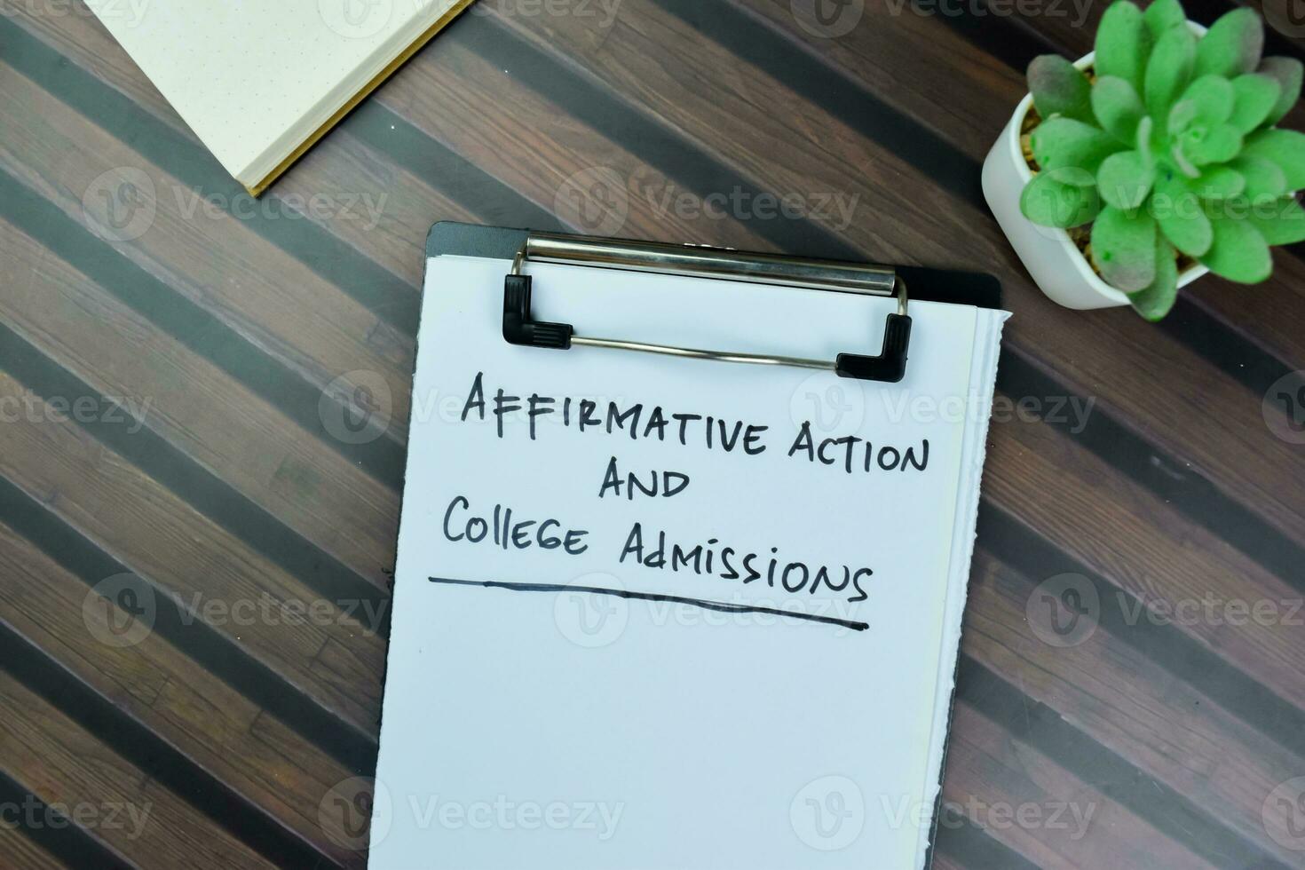 Concept of Affirmative Action and College Admissions write on paperwork isolated on Wooden Table. photo