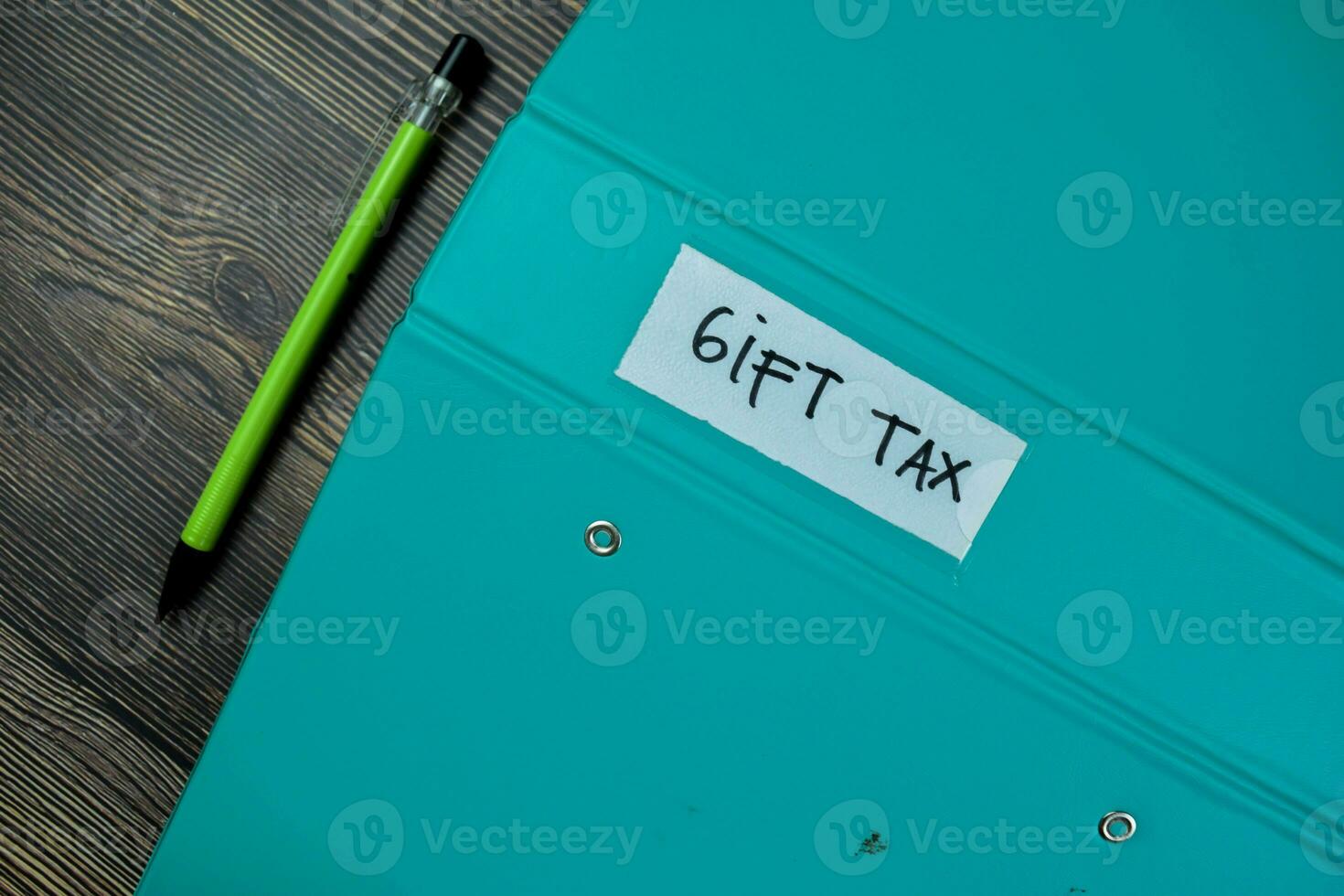 Concept of Gift Tax write on the piece of paper isolated on Wooden Table. photo