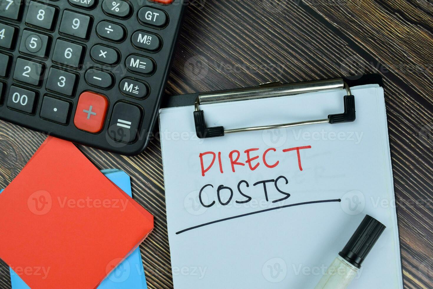 Direct Costs write on a paperwork isolated on Wooden Table. photo
