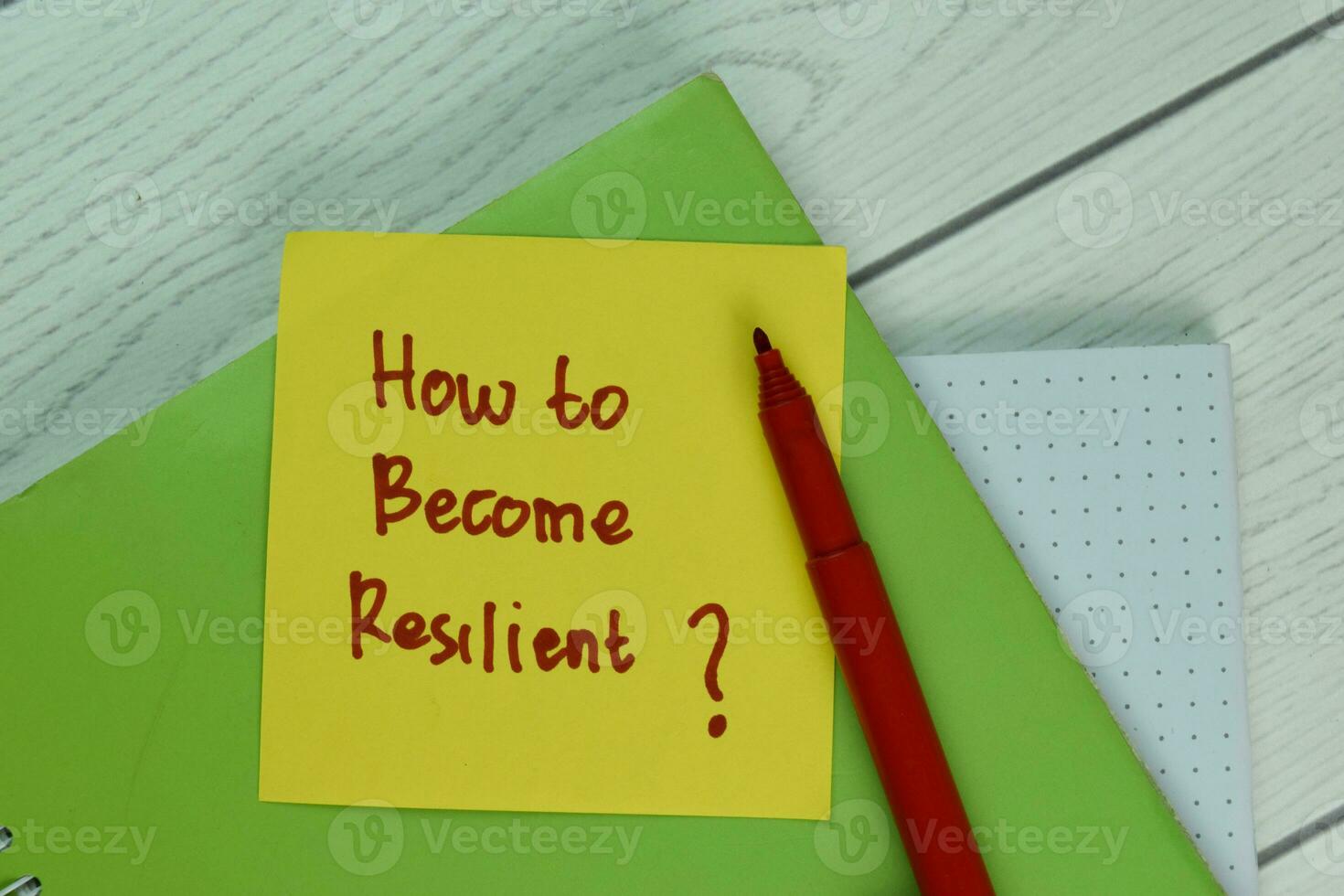 How To Become Resilient write on a book isolated on Wooden Table. photo